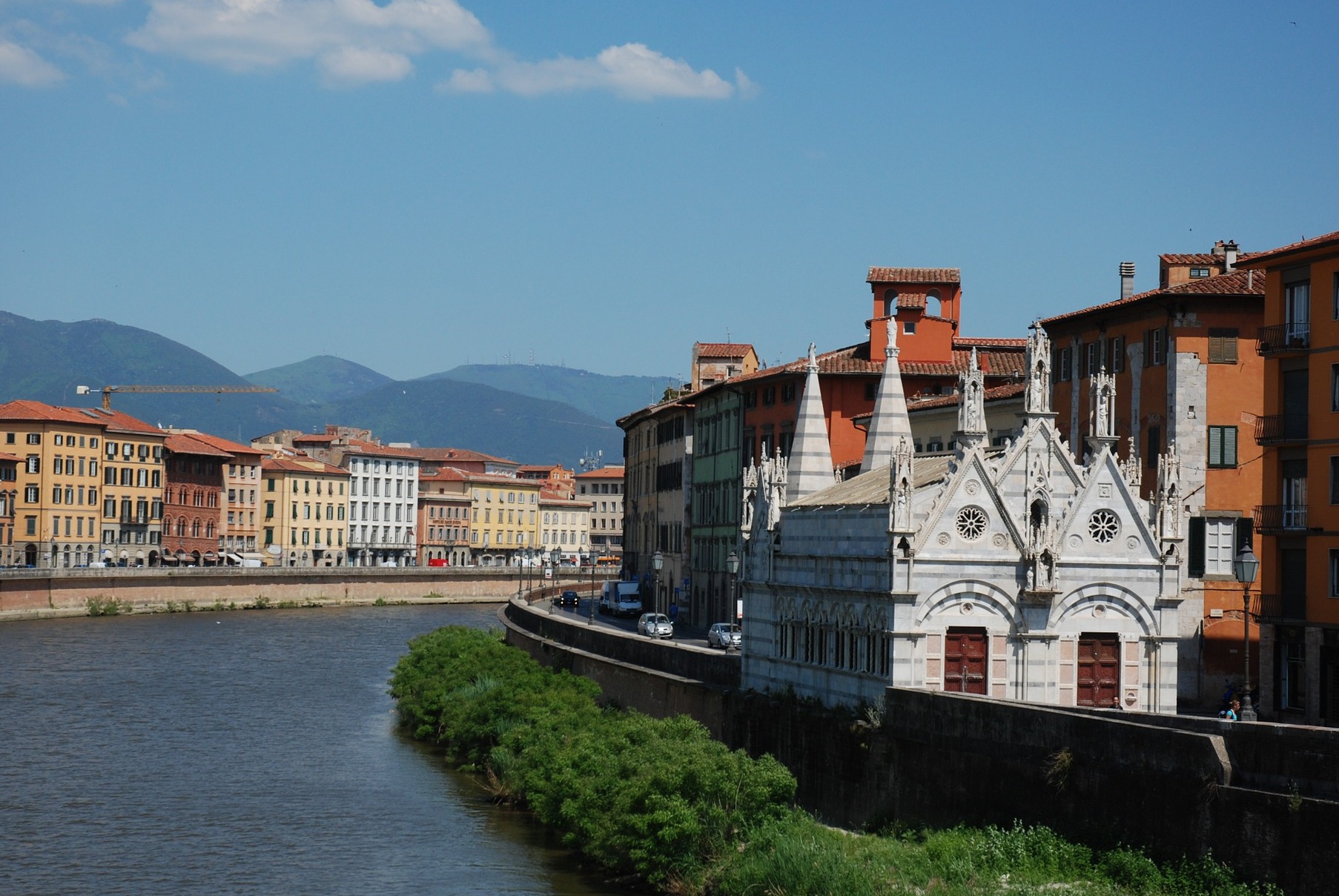 Opierając się na parapecie Lungarno Gambacorti, z widokiem na rzekę w punkcie f - Pisa | Secret World Trip Planner