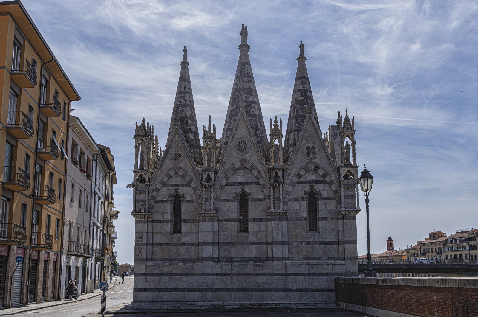 Opierając się na parapecie Lungarno Gambacorti, z widokiem na rzekę w punkcie f - Pisa | Secret World Trip Planner